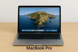 A silver MacBook Pro on a wooden table, displaying a serene ocean island wallpaper at the macbook pro repair service shop. The screen shows app icons, creating a calm and modern feel.