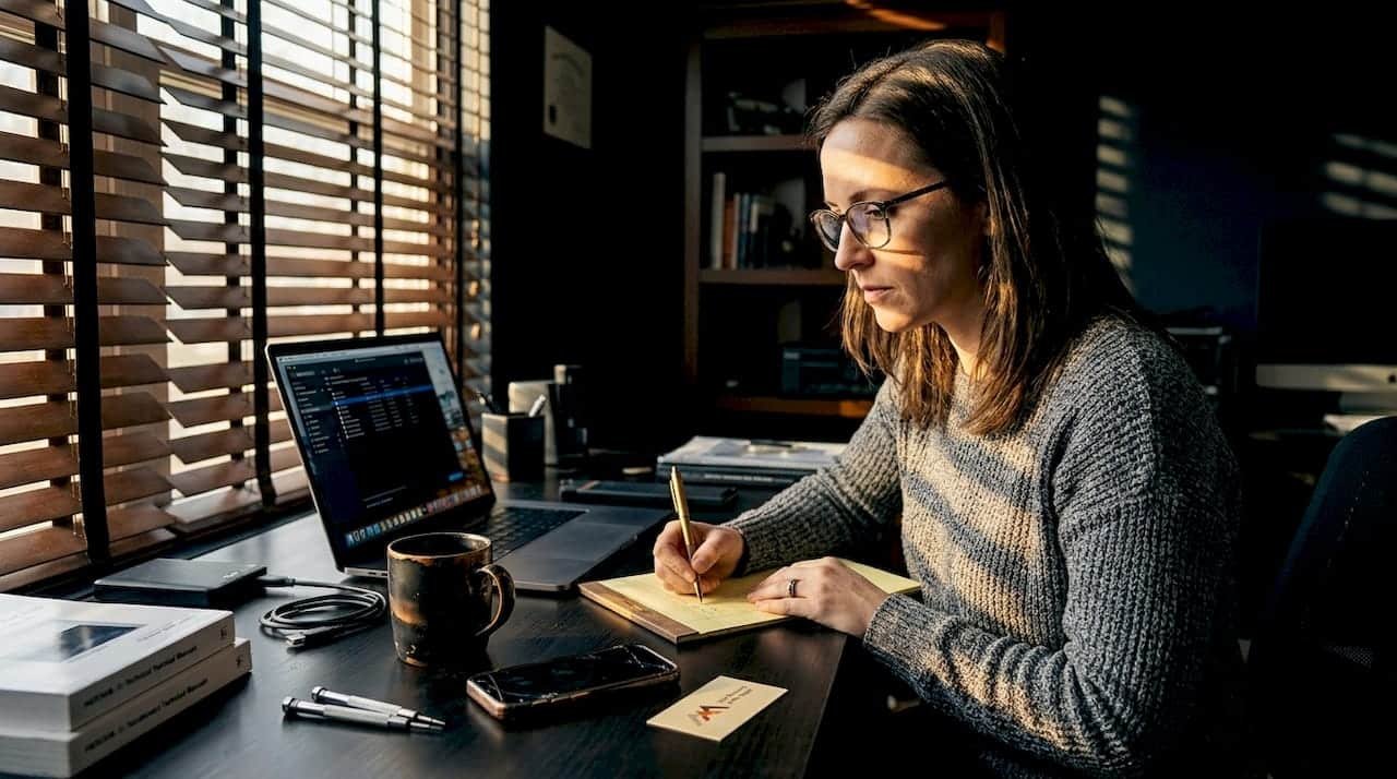 Woman troubleshooting MacBook at home desk
