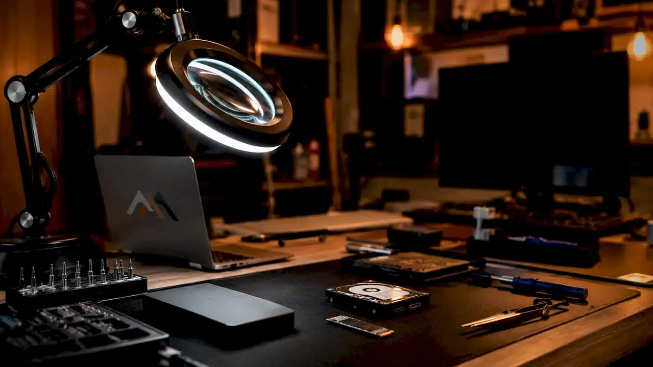 Technician inspecting laptop SSD on workbench