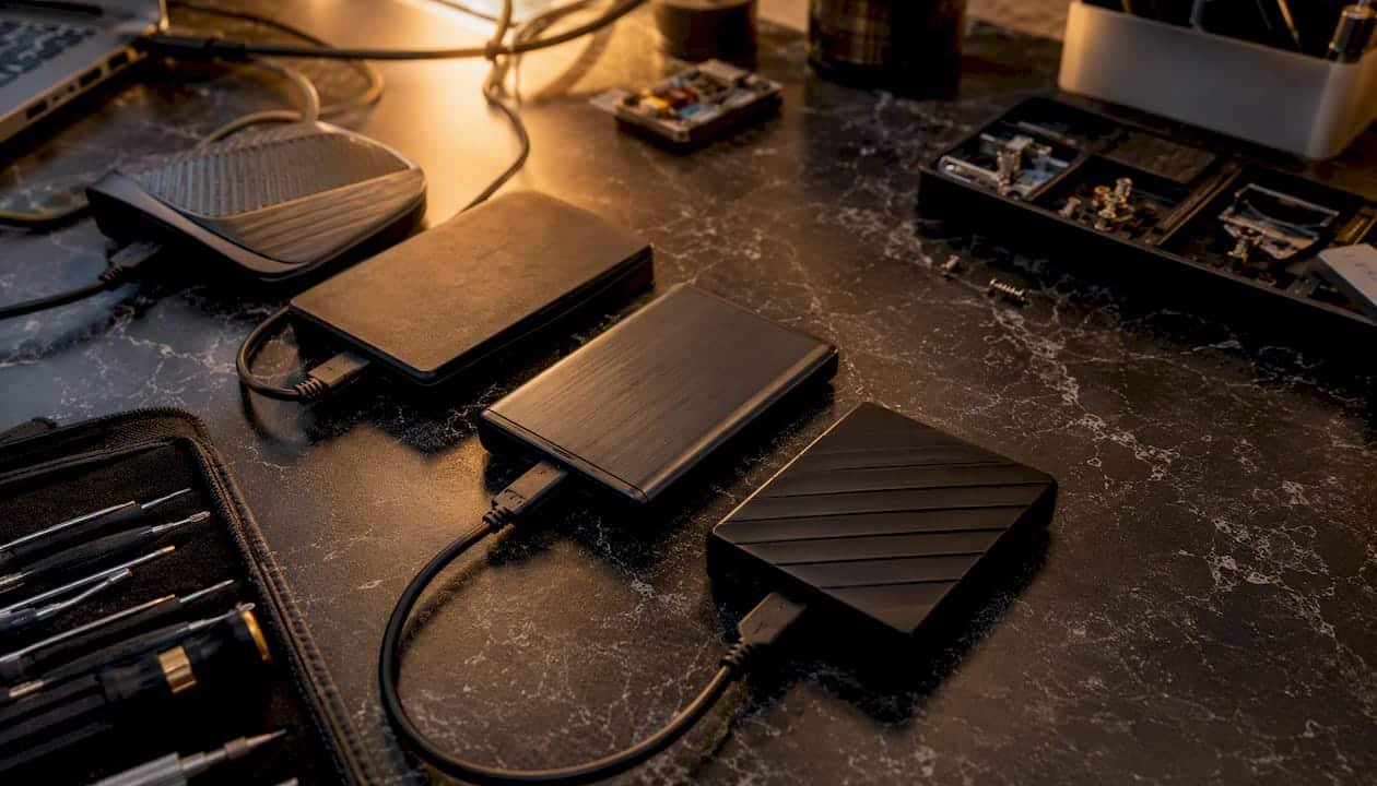 1786347587961_Close-up-of-external-drives-connected-on-workbench Close-up of external drives connected on workbench