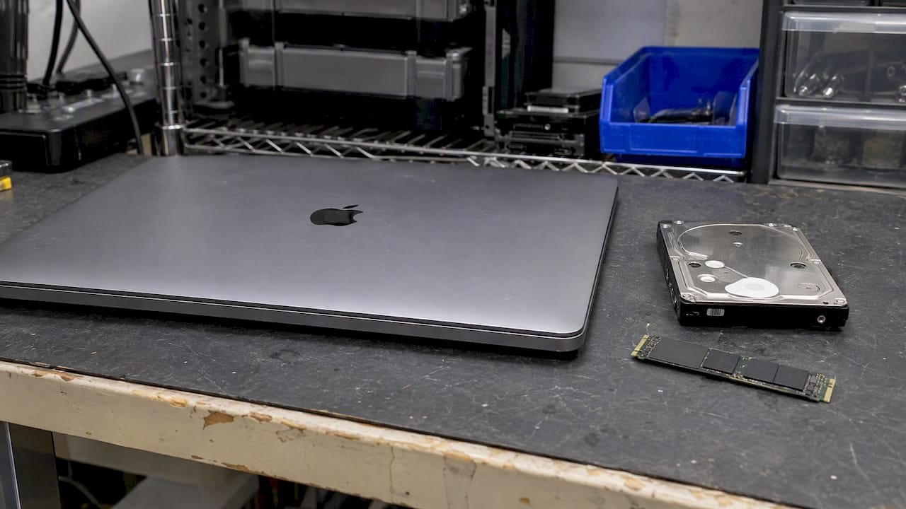 MacBook Pro beside hard drive and SSD