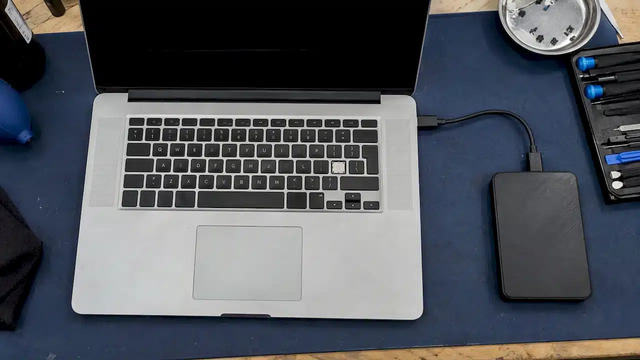 MacBook keyboard beside an external hard drive
