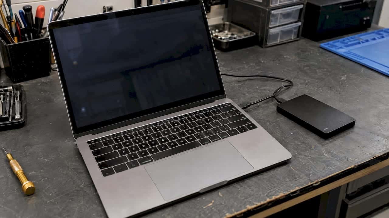 1791951169867_Dim-MacBook-beside-an-external-hard-drive Dim MacBook beside an external hard drive